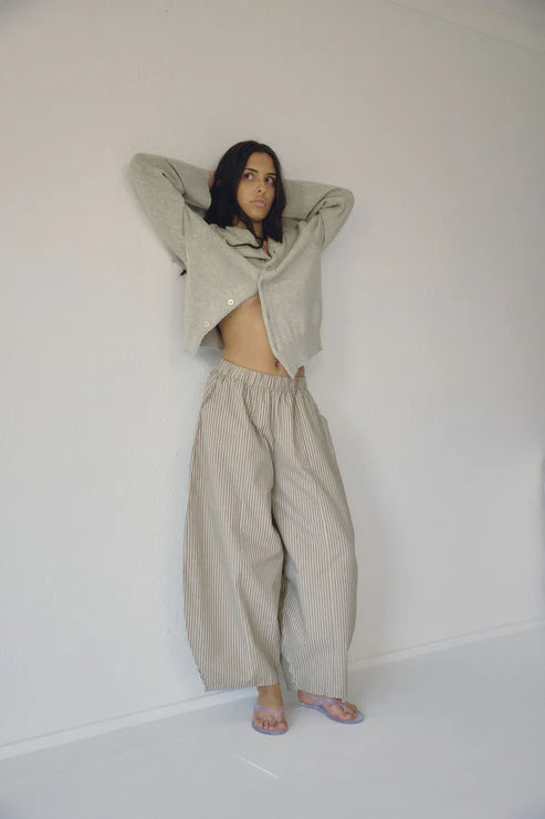 Person wearing a beige outfit with a white background