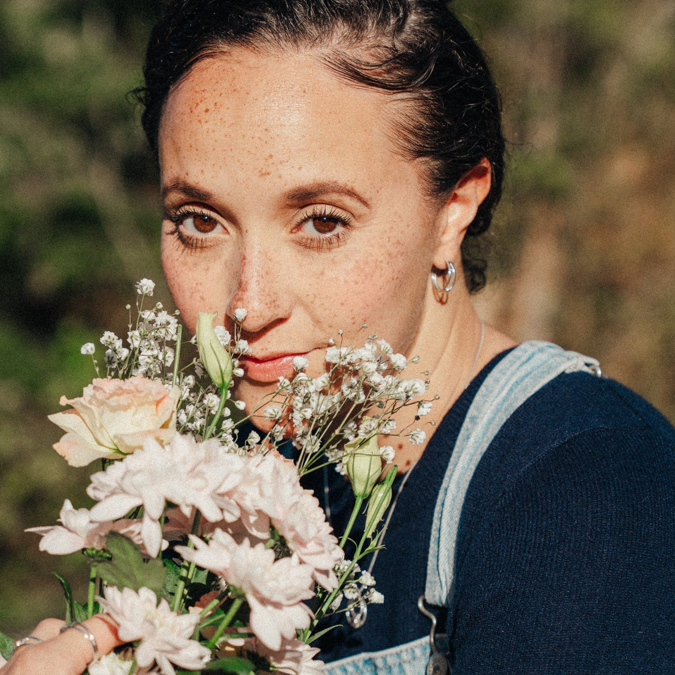 Woman holding a bouquet of flowers with a blurred natural background
