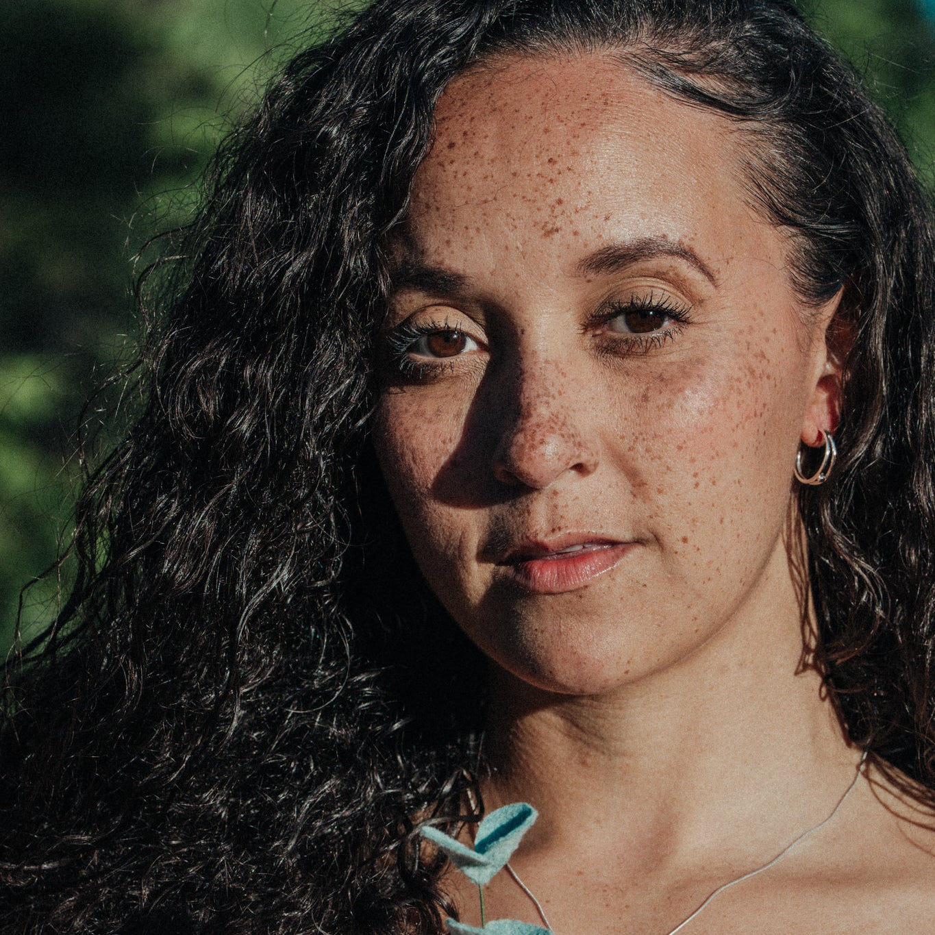 Woman wearing an earring in a natural setting
