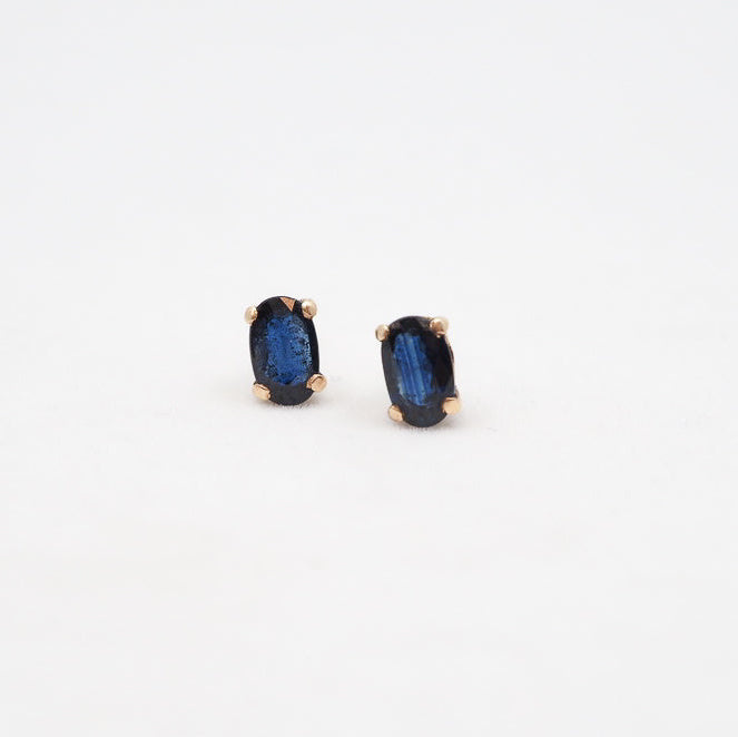 Pair of blue gemstone stud earrings on a white background