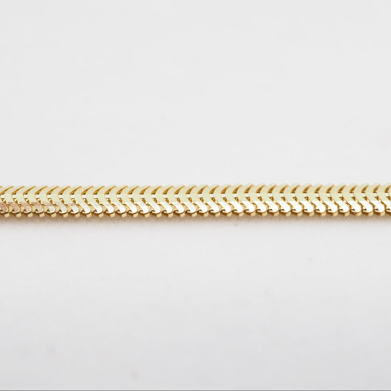 Gold chain on a light gray background