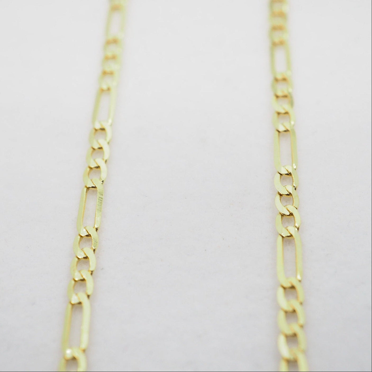 Gold chain on a light gray background