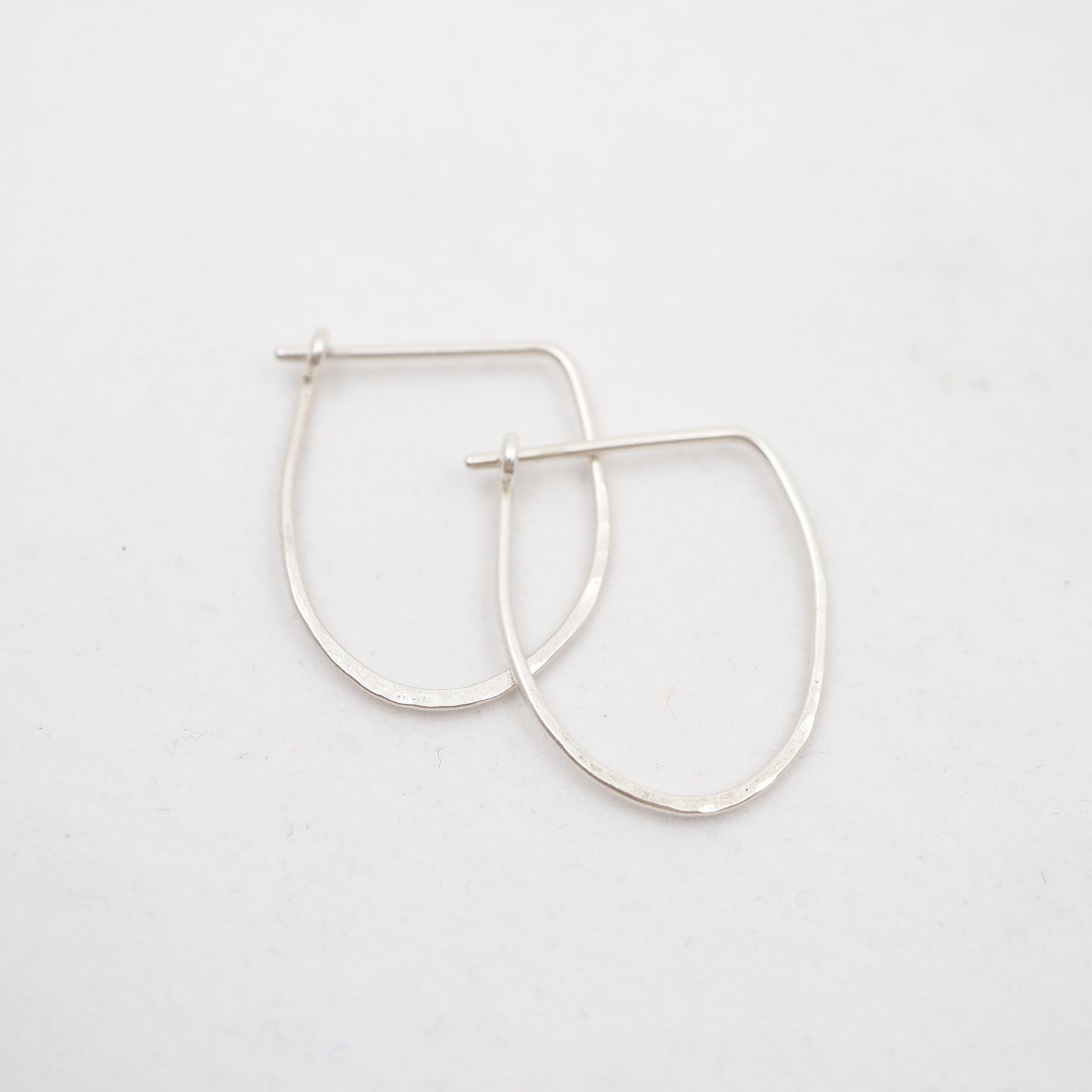 Silver hoop earrings on a light gray background