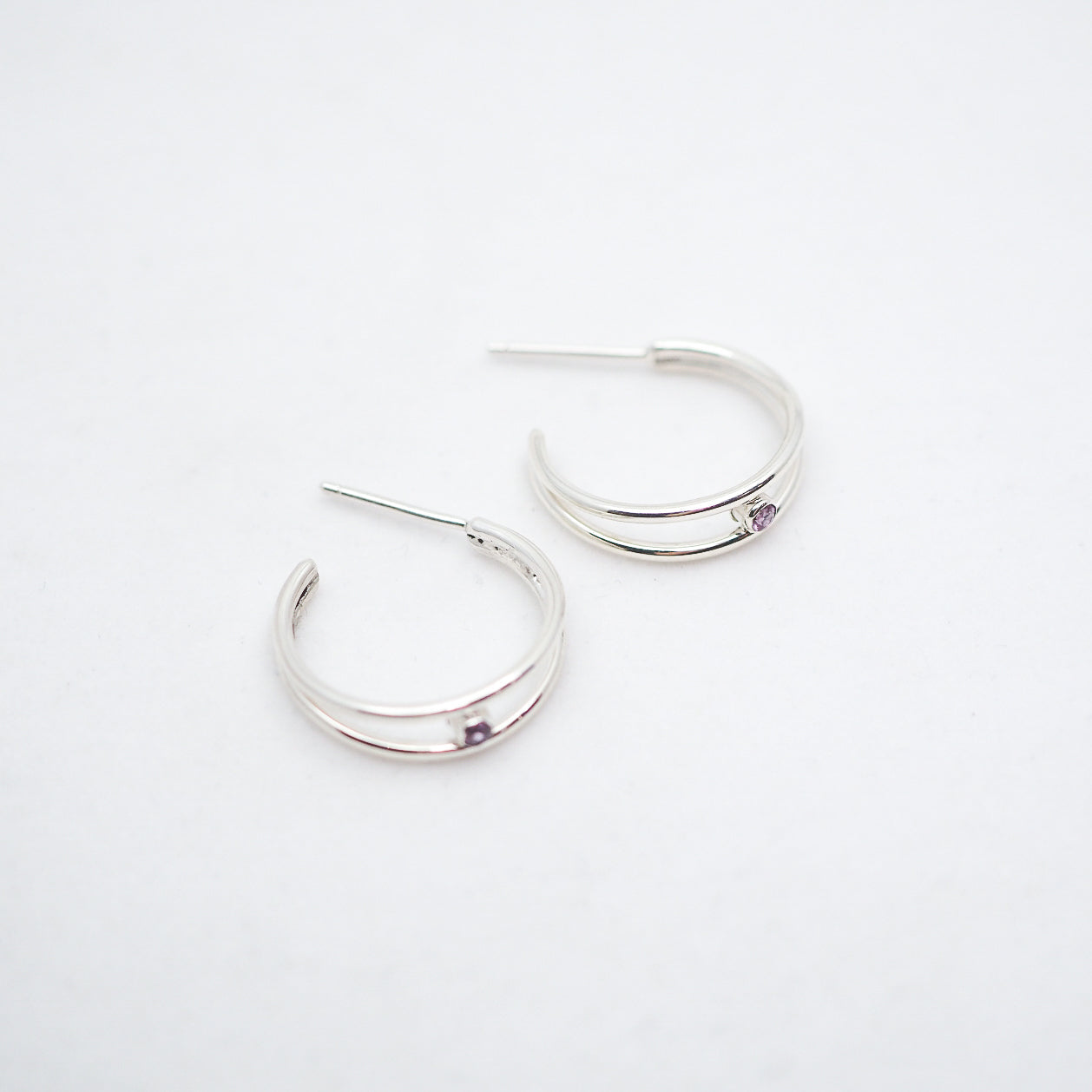 Pair of silver hoop earrings on a light gray background