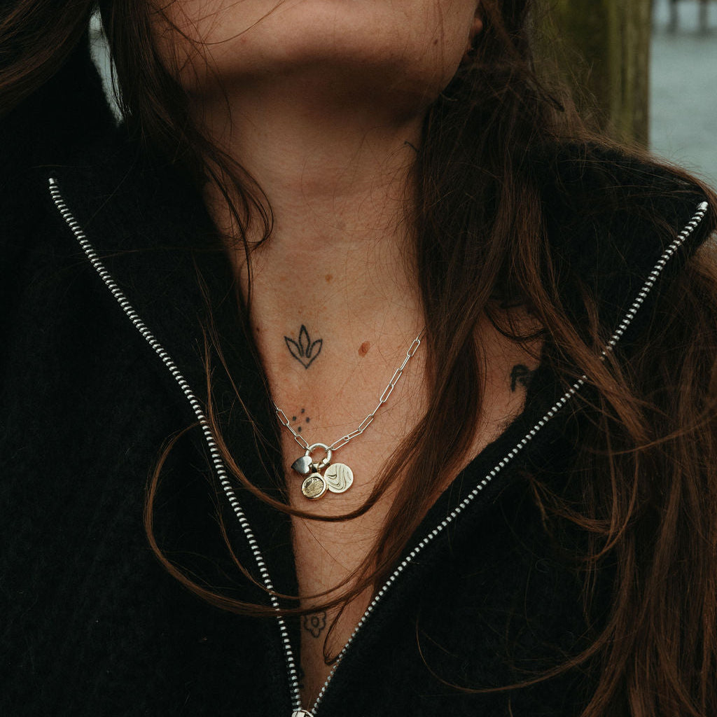 Person with long hair and necklaces against a blurred background