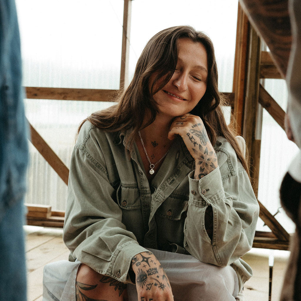 Woman with tattoos sitting on a chair indoors