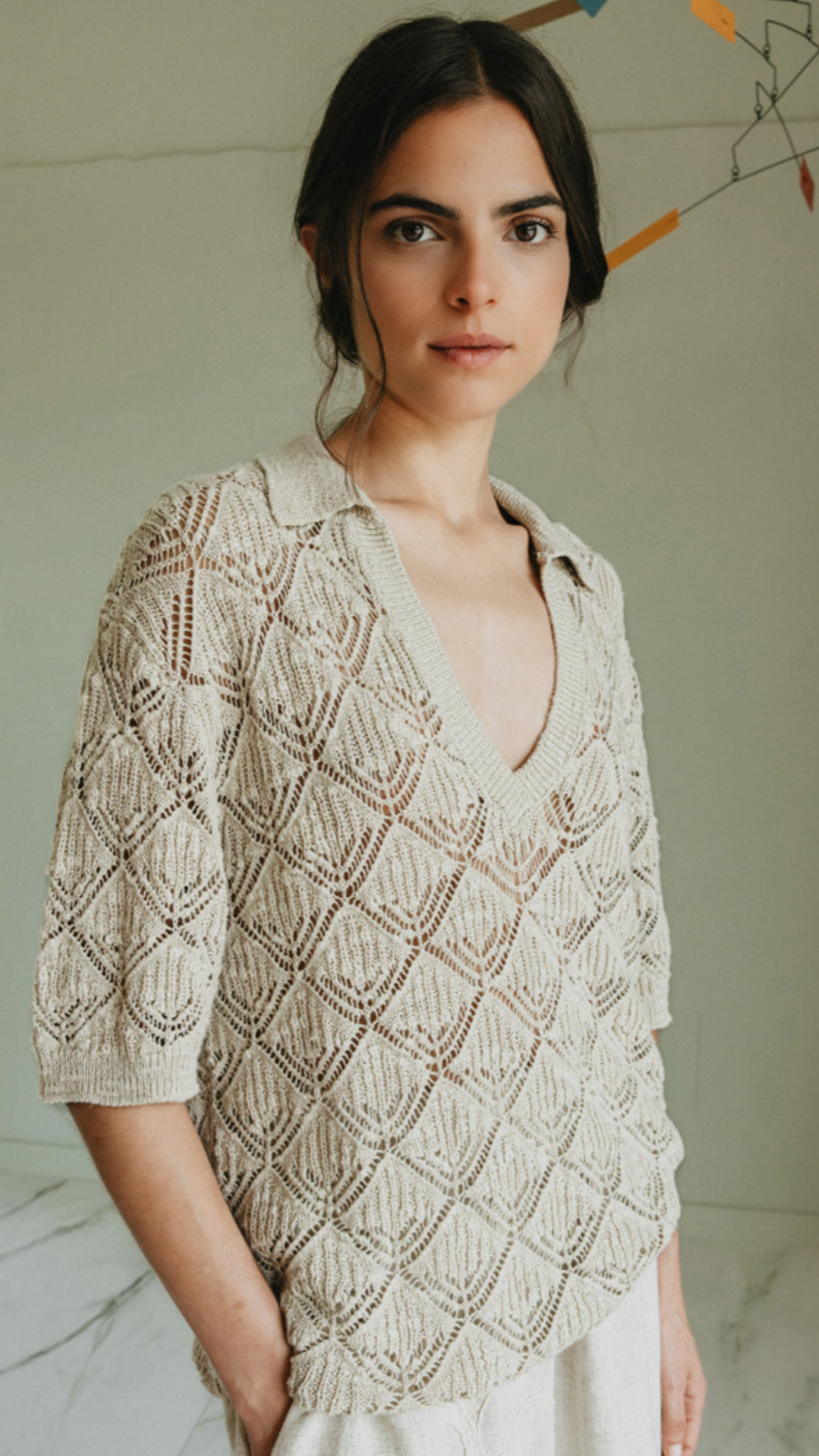 Woman wearing a beige knitted sweater with a neutral background
